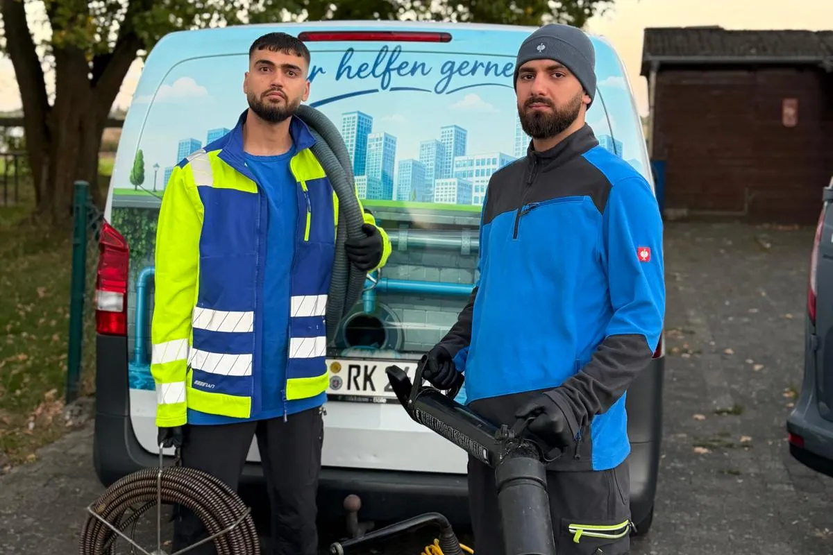 Zwei Techniker der Rohrreinigung Fachbetrieb mit Spirale und Spülgerät am Einsatzwagen