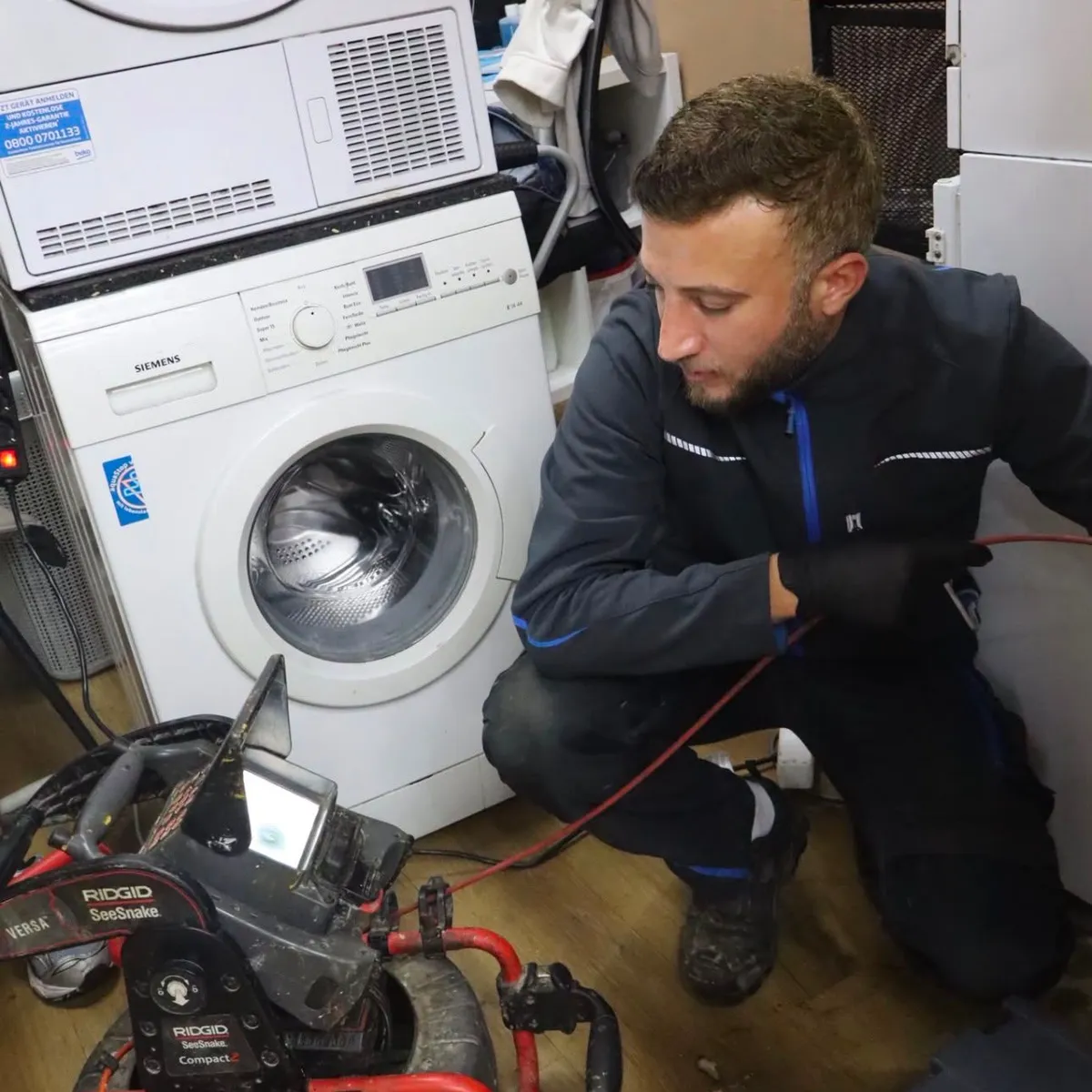Techniker arbeitet mit der Rohrkamera an einem Abfluss im Hauswirtschaftsraum
