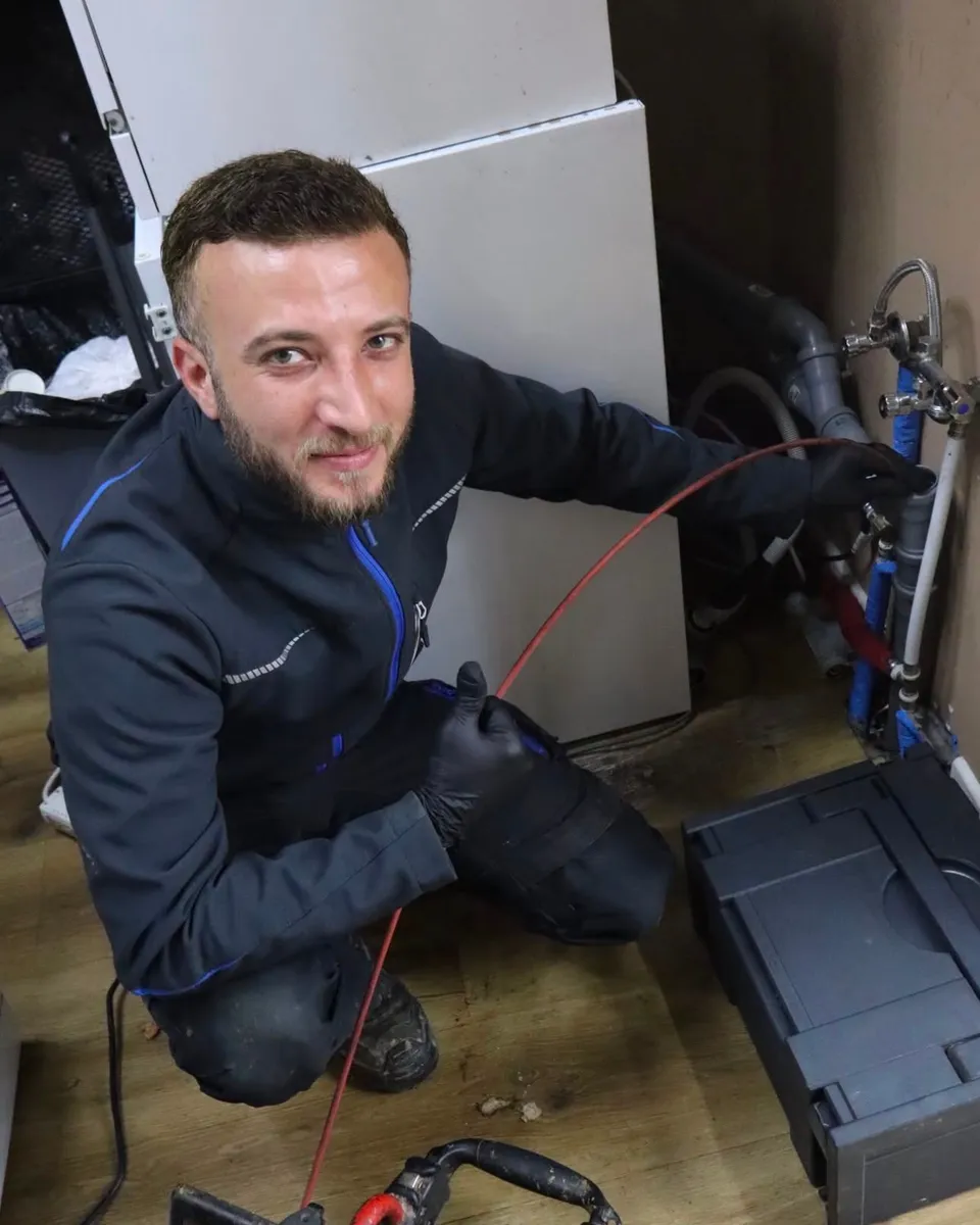 Techniker führt die Rohrkamera an einem Abfluss im Hauswirtschaftsraum ein