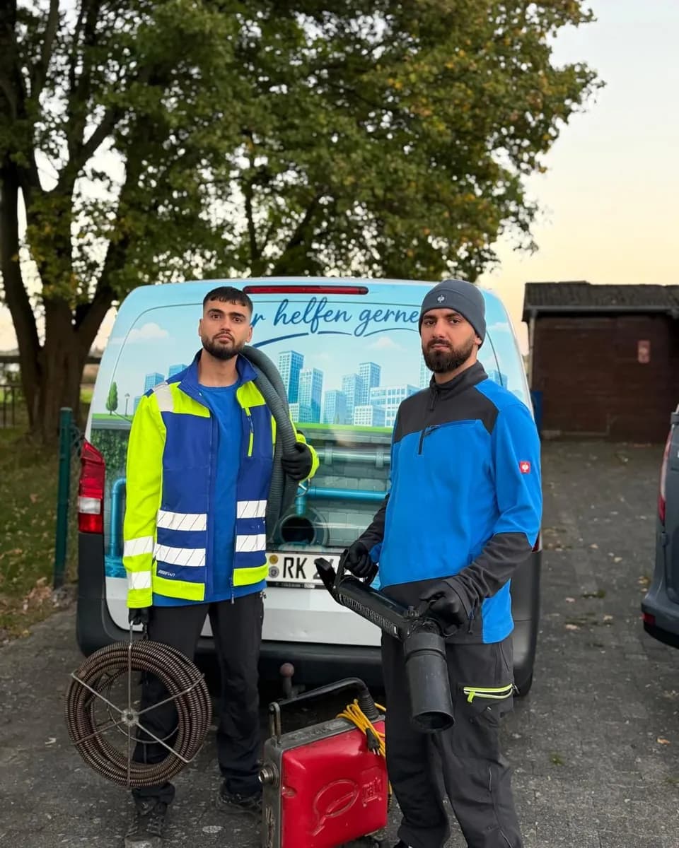 Zwei Techniker der Rohrreinigung Fachbetrieb mit Spirale und Spülgerät am Einsatzwagen